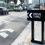 Drive thru sign with shop background.